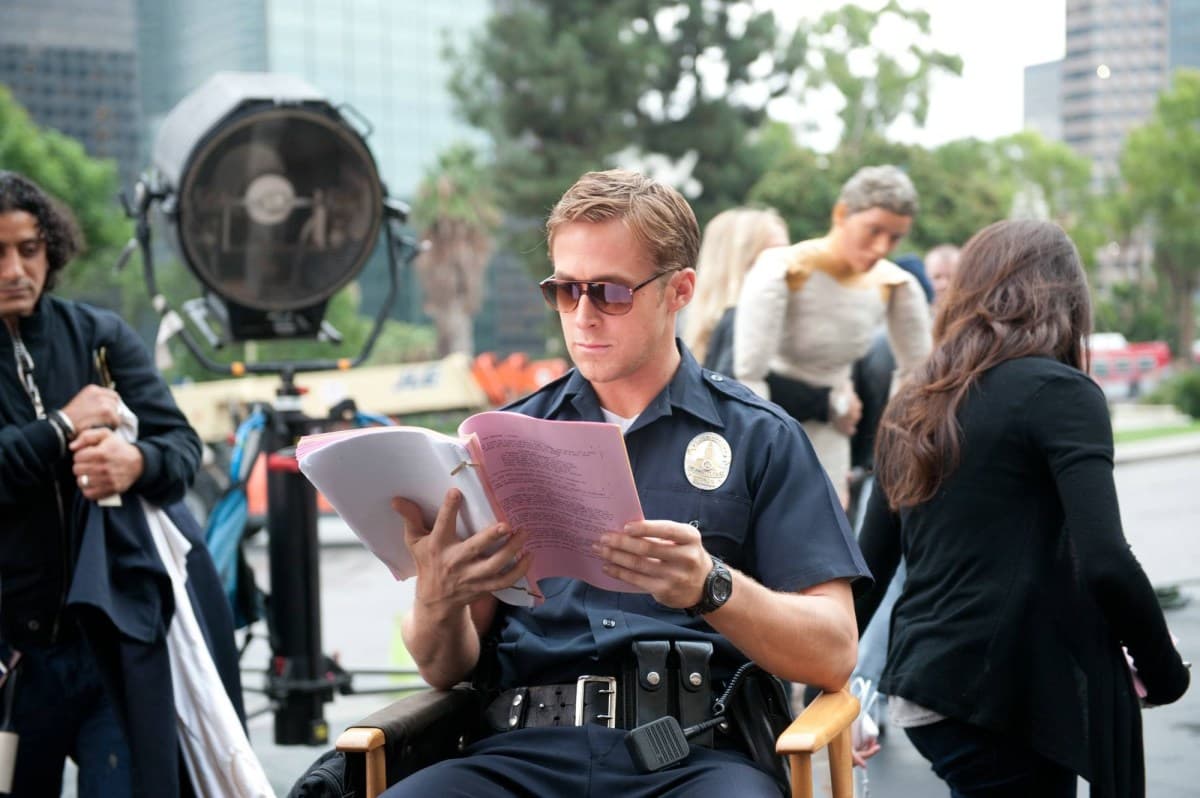 Behind-the-scenes image of Ryan Gosling reviewing material during Drive production.