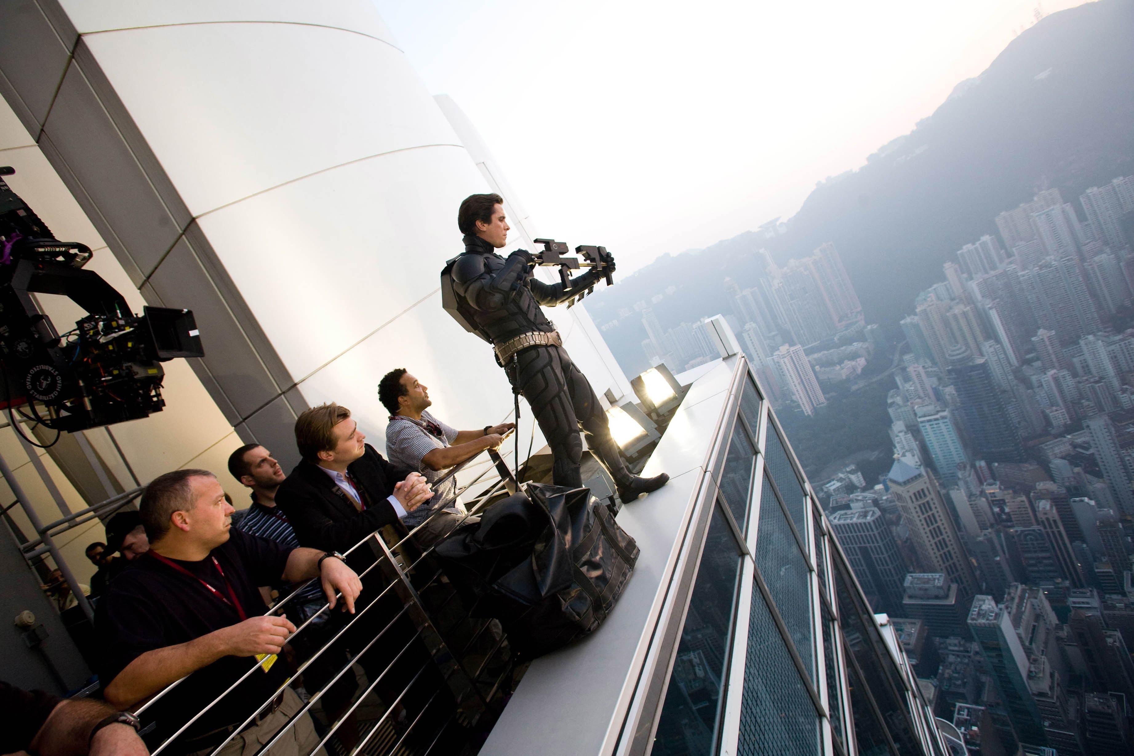 Behind-the-scenes image of The Dark Knight crew filming from a high-rise rooftop with IMAX camera equipment.