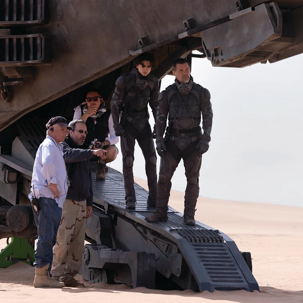 Behind-the-scenes image of Denis Villeneuve, cast, and crew working on the desert location for Dune.