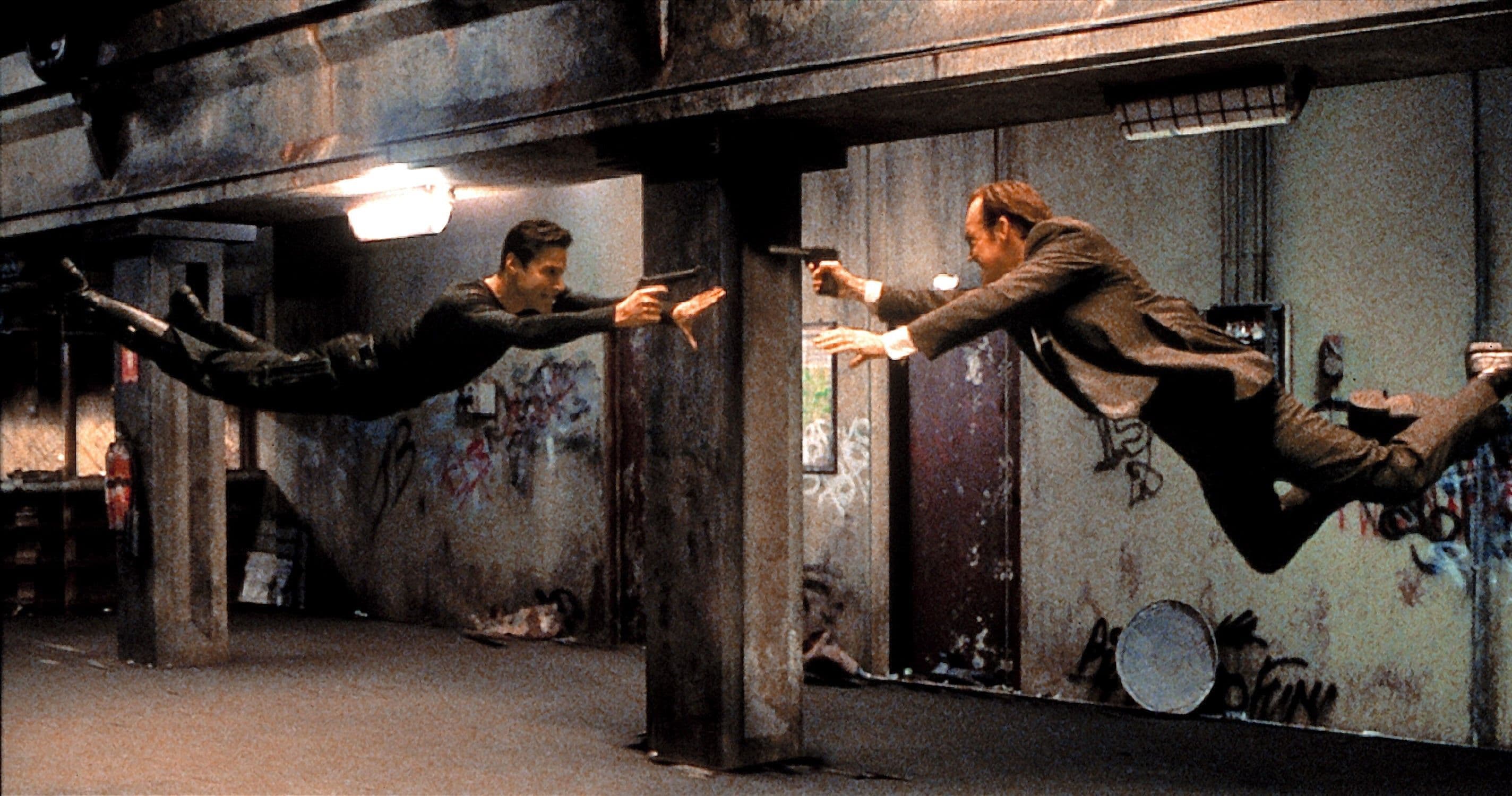 Behind-the-scenes image of the dojo fight being staged with stunt support and wire work.
