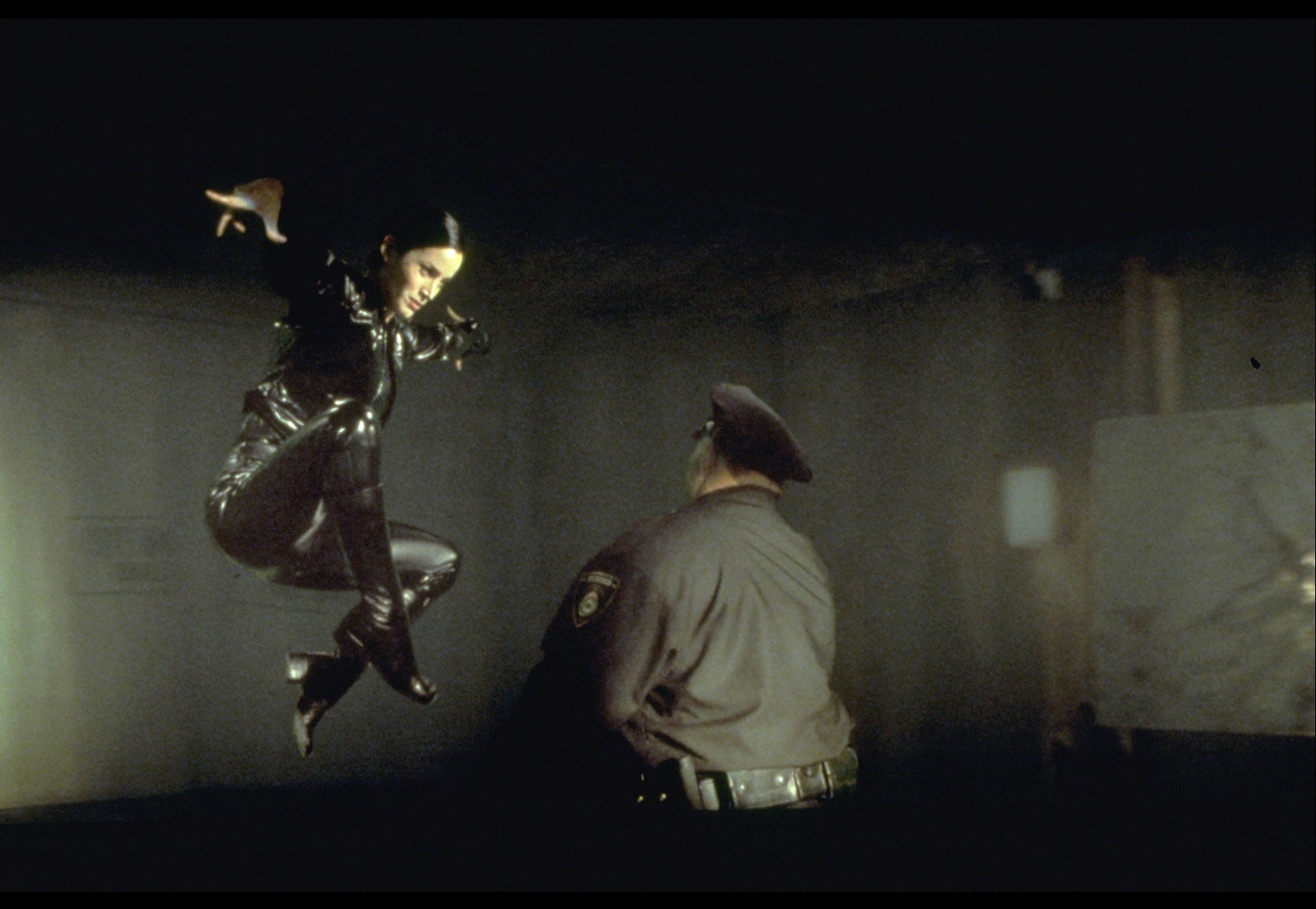 Behind-the-scenes image of The Matrix action being staged with wire-rig and crew support.