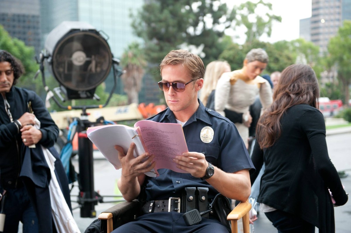 Behind-the-scenes image of Ryan Gosling reviewing material during Drive production.