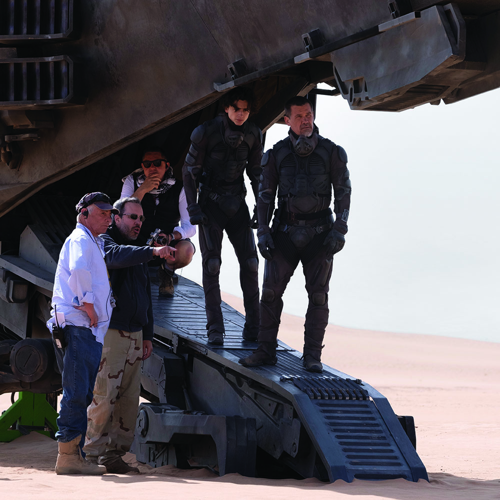 Behind-the-scenes image of Denis Villeneuve, cast, and crew working on the desert location for Dune.