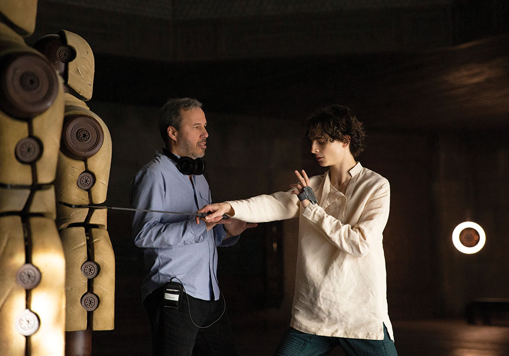 Behind-the-scenes image of Denis Villeneuve working with Timothée Chalamet during Dune production.