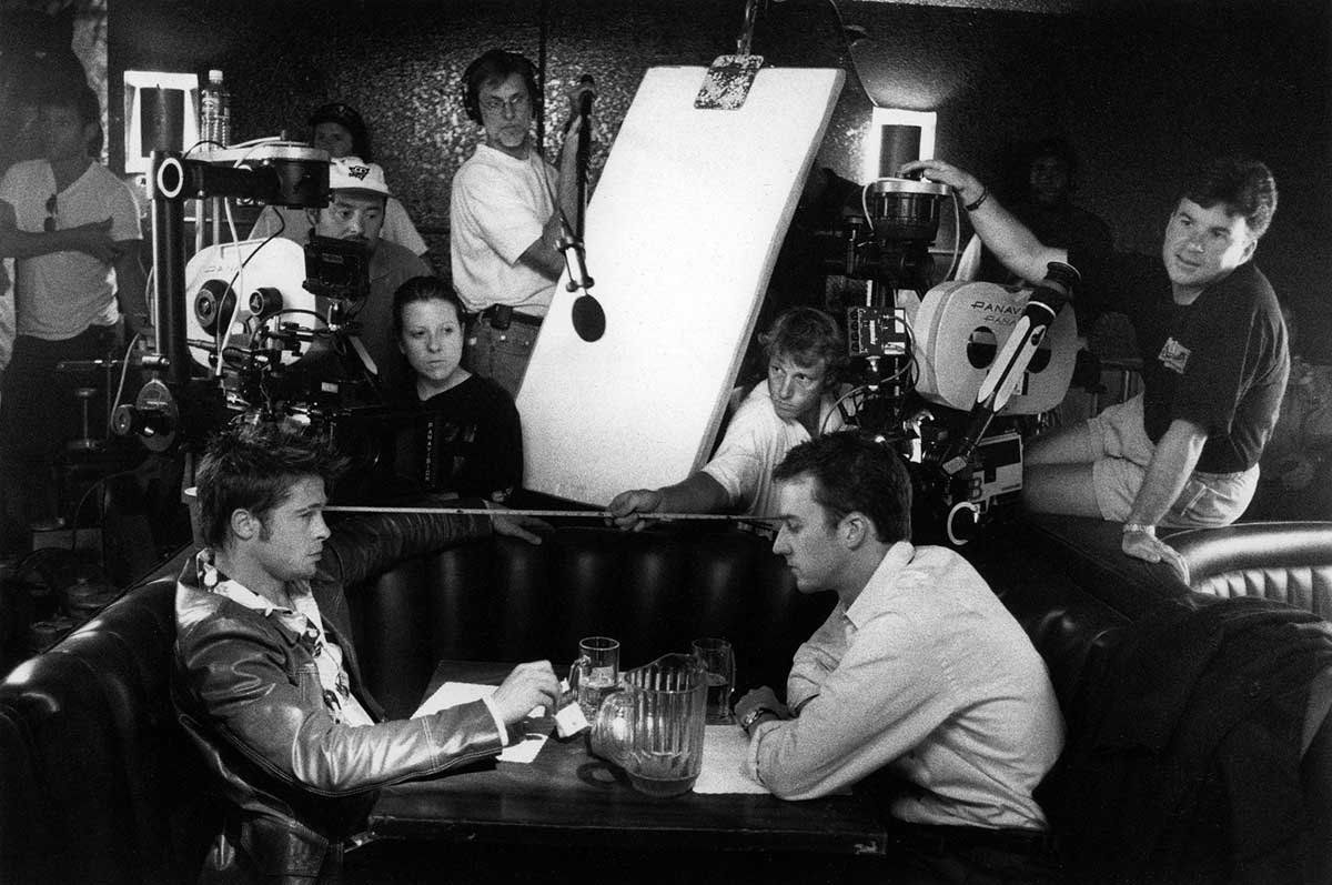 Behind-the-scenes image of the Fight Club crew filming around the basement table set.