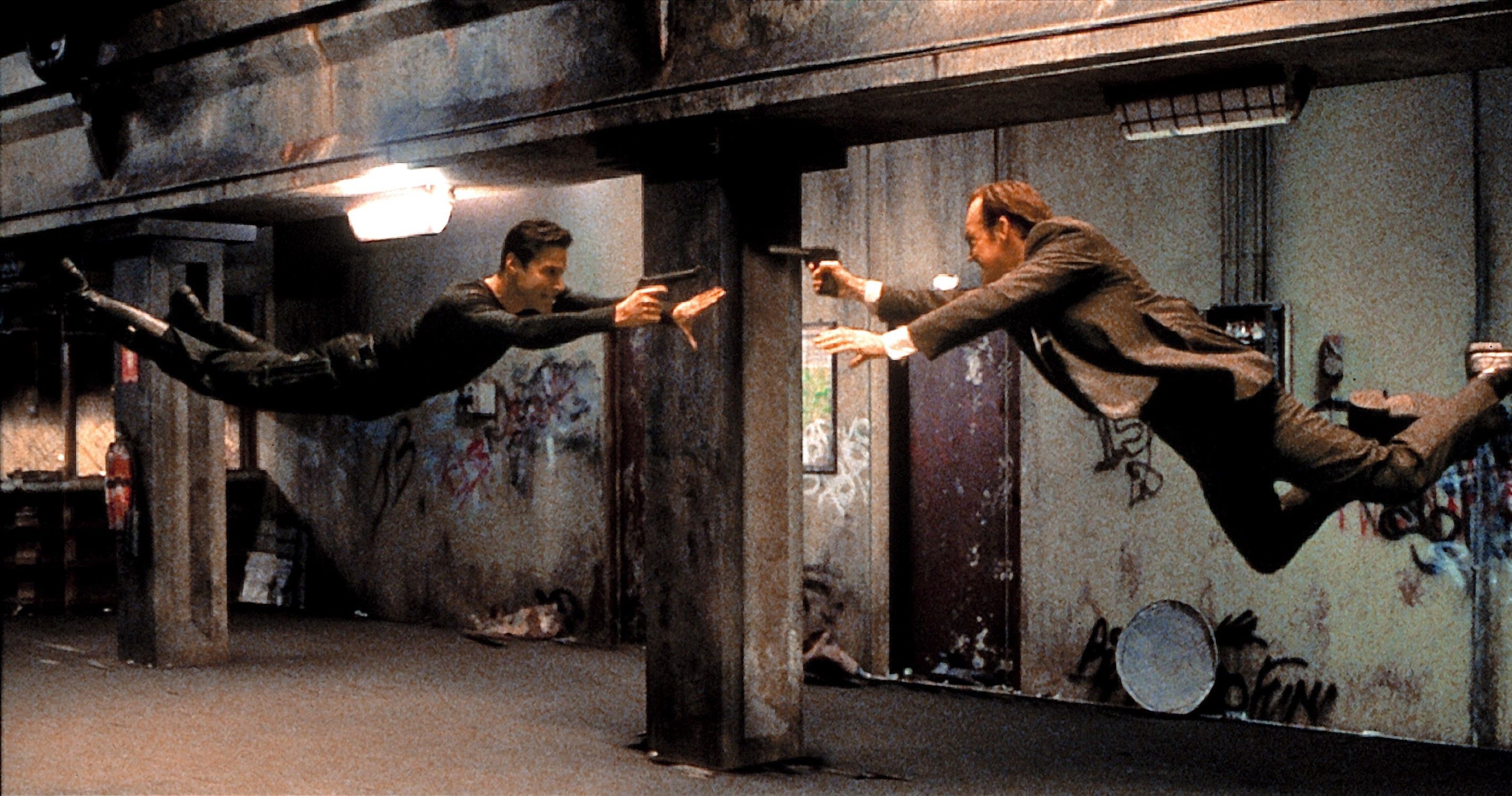 Behind-the-scenes image of the dojo fight being staged with stunt support and wire work.